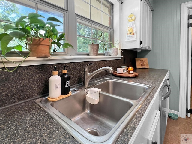 interior space featuring sink, white cabinetry, and dishwasher