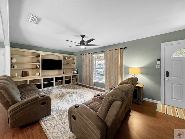 living room with dark wood-type flooring and ceiling fan