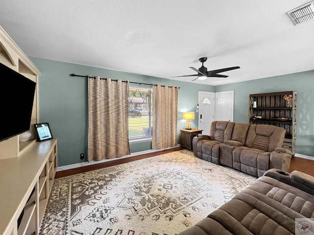 living room featuring wood-type flooring and ceiling fan