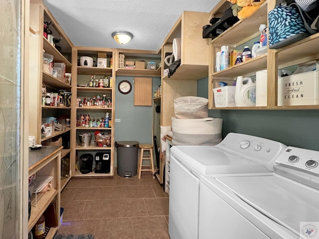 laundry area featuring a textured ceiling, dark tile patterned floors, and separate washer and dryer