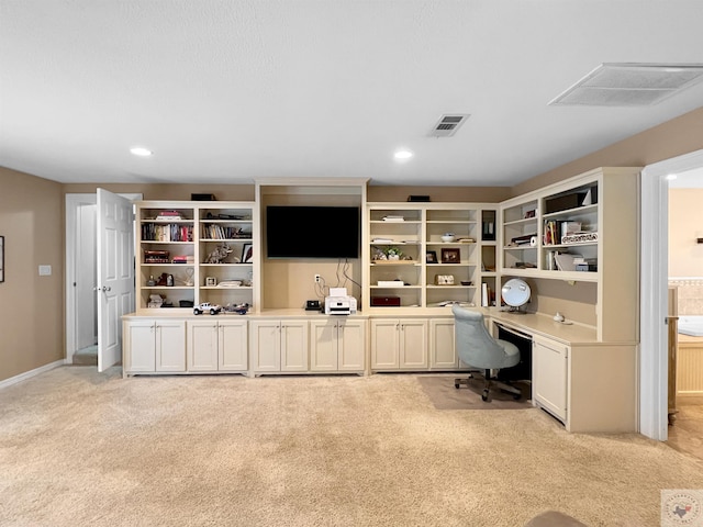 carpeted home office featuring built in desk