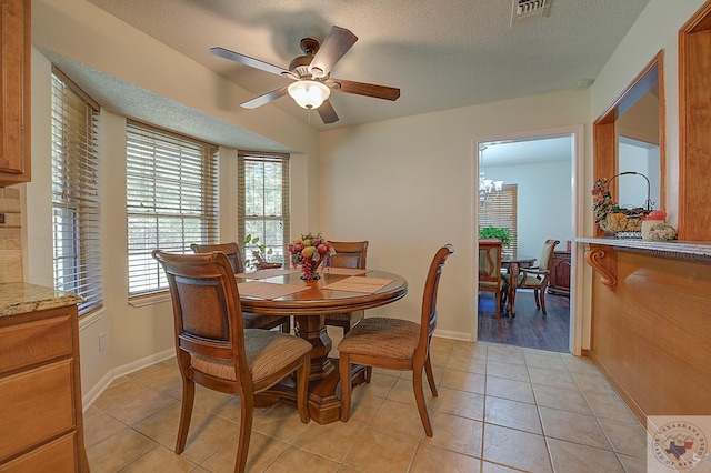 tiled dining area featuring a textured ceiling and ceiling fan