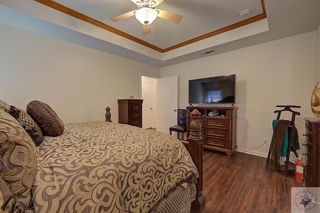 bedroom with ceiling fan, a tray ceiling, dark hardwood / wood-style flooring, and crown molding