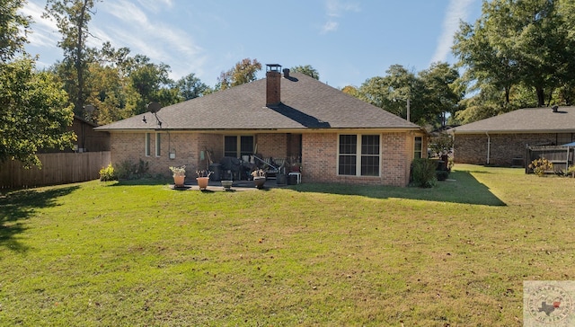 back of property with a lawn and a patio