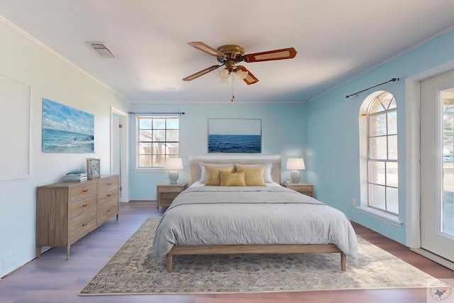 bedroom with ceiling fan, ornamental molding, and light wood-type flooring