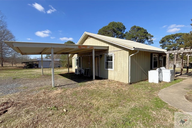 view of side of home featuring a carport and a lawn