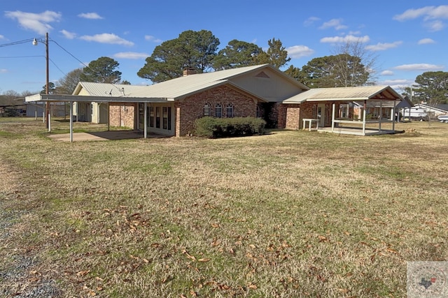 rear view of house featuring a yard and a carport