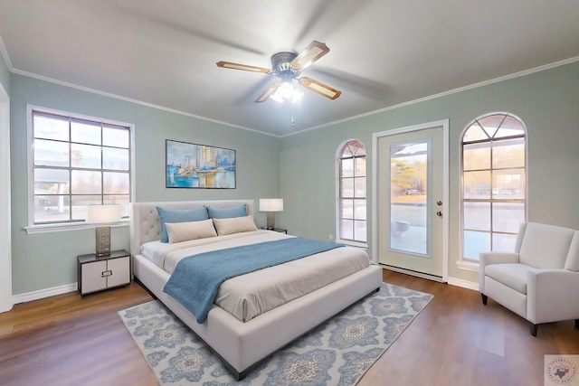 bedroom featuring crown molding, baseboards, ceiling fan, and wood finished floors