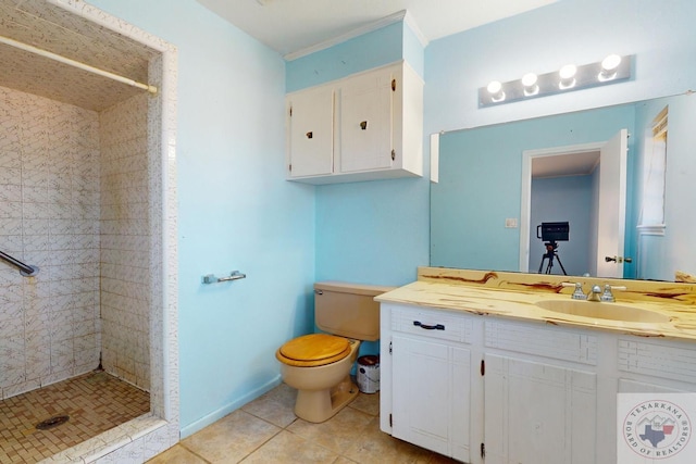 bathroom featuring a tile shower, toilet, tile patterned flooring, and vanity