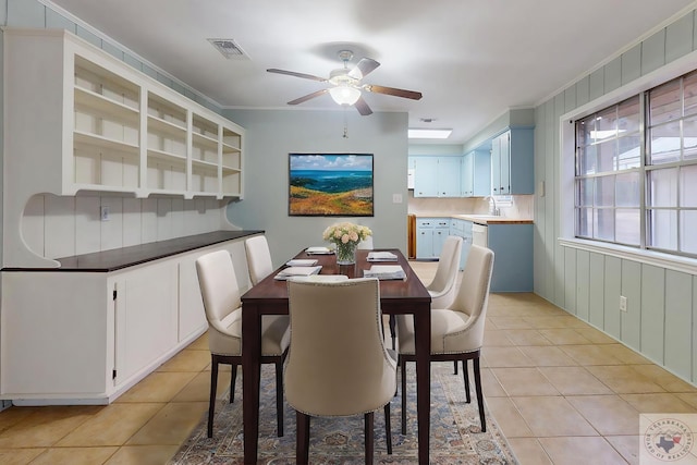 dining room with light tile patterned flooring, crown molding, and visible vents