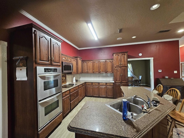 kitchen with crown molding, sink, light hardwood / wood-style floors, decorative backsplash, and stainless steel appliances