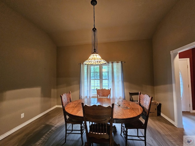 dining room featuring dark hardwood / wood-style flooring and vaulted ceiling