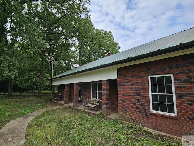 view of side of property with a patio area and a yard