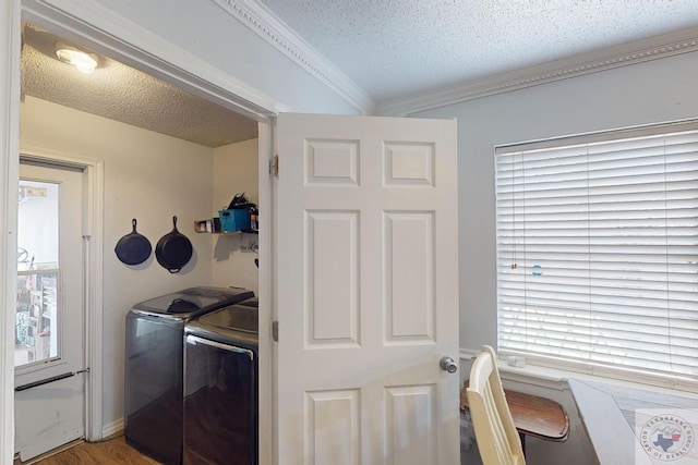 laundry area with hardwood / wood-style floors, a textured ceiling, and washer and dryer