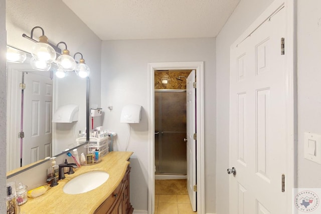 bathroom with a shower with door, a textured ceiling, tile patterned floors, and vanity