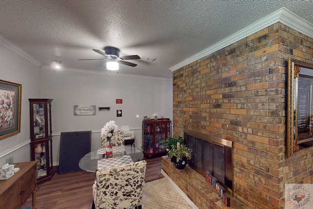 dining room featuring ceiling fan, ornamental molding, dark hardwood / wood-style flooring, and a textured ceiling