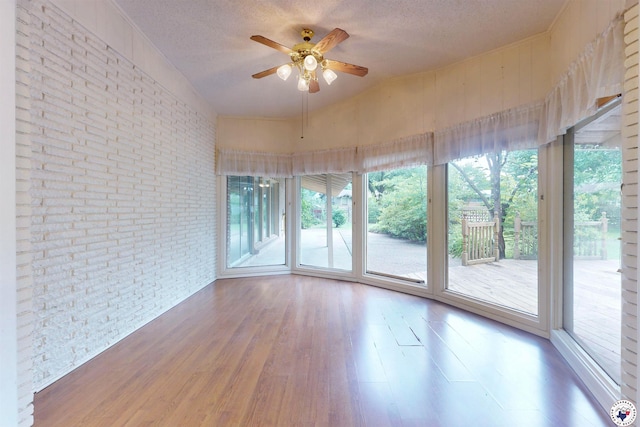 1315 Holloway Dr, Texarkana, TX 75503 - empty room with brick wall, wood finished floors, ceiling fan, and a textured ceiling