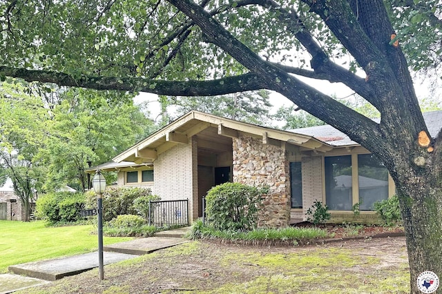 1315 Holloway Dr, Texarkana, TX 75503 - view of front facade with brick siding, a front yard, and stone siding