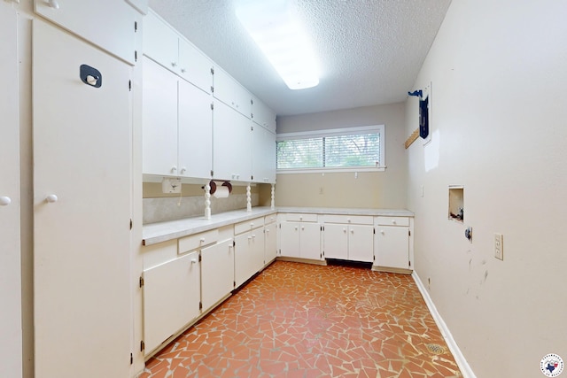 1315 Holloway Dr, Texarkana, TX 75503 - laundry room with cabinet space, a textured ceiling, and washer hookup