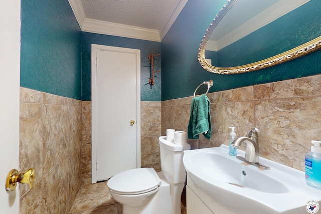 1315 Holloway Dr, Texarkana, TX 75503 - half bathroom featuring tile walls, ornamental molding, vanity, wainscoting, and a textured ceiling