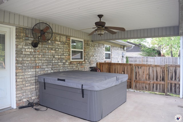 view of patio / terrace with a hot tub, ceiling fan, and fence