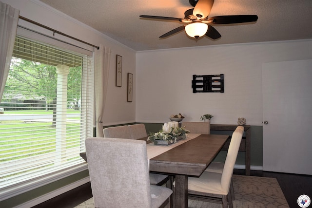 dining space featuring baseboards, a ceiling fan, wood finished floors, and ornamental molding