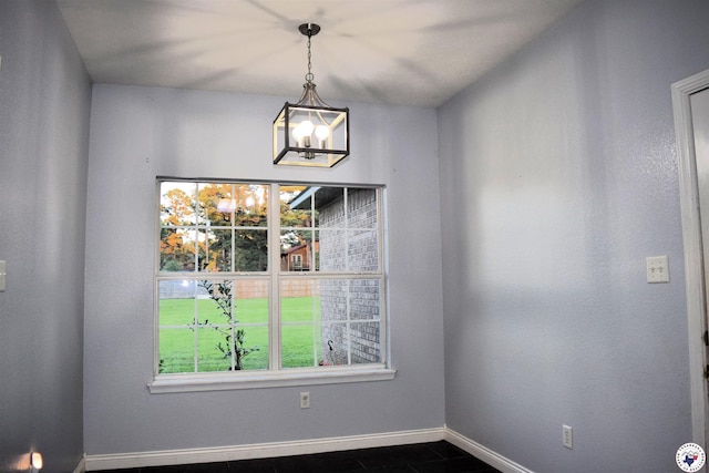 4802 David Dr, Texarkana, TX 75503 - unfurnished dining area featuring a chandelier, baseboards, and dark tile patterned flooring