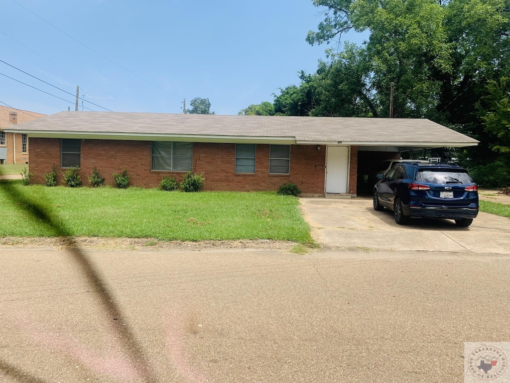 ranch-style home featuring a front lawn and a carport