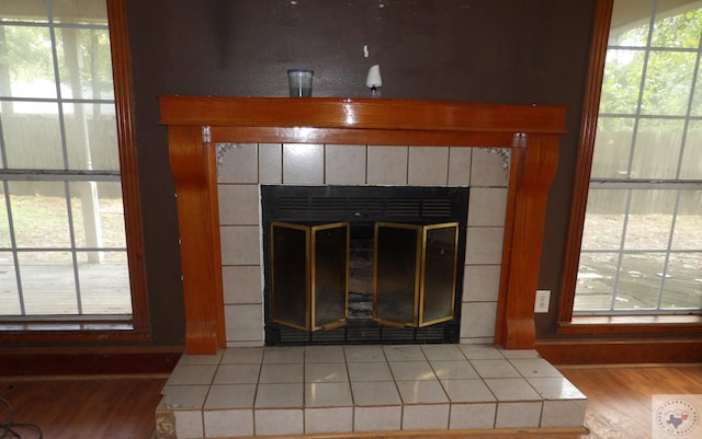 details featuring hardwood / wood-style flooring and a tile fireplace