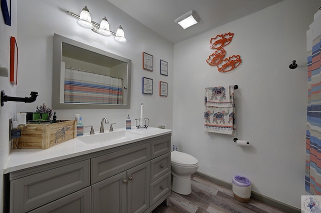 bathroom with hardwood / wood-style floors, vanity, and toilet