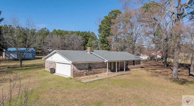 back of property with a yard and a garage