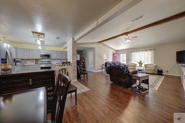 living room with ceiling fan, vaulted ceiling with beams, and dark hardwood / wood-style flooring