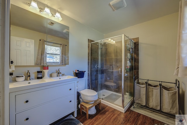 bathroom featuring hardwood / wood-style floors, vanity, and a shower with door