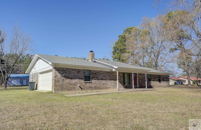 back of house featuring a garage and a yard