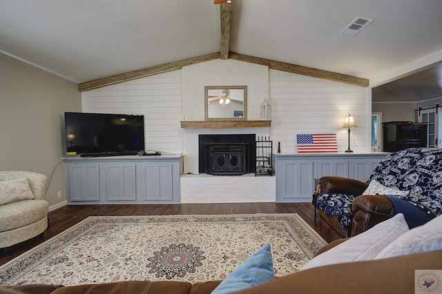 living room featuring a fireplace, a barn door, dark wood-type flooring, and vaulted ceiling with beams