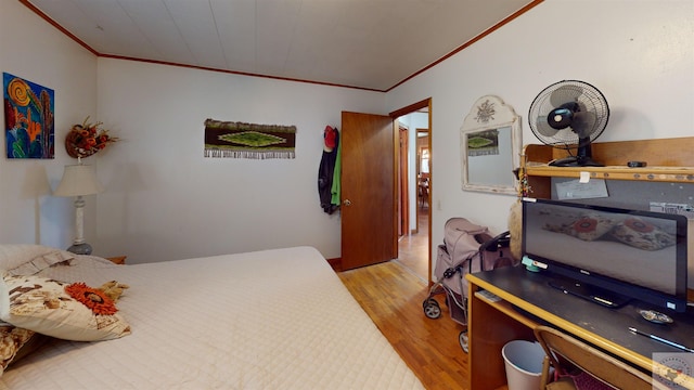 bedroom with crown molding and light wood-type flooring