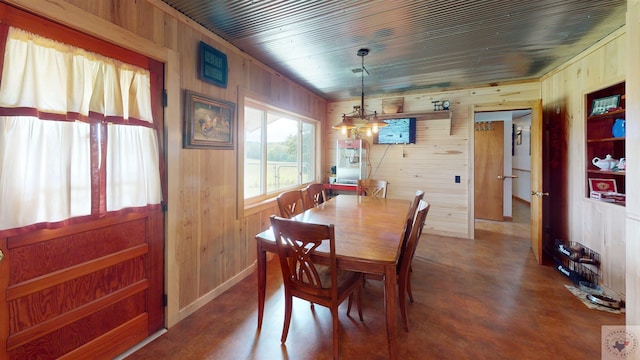 dining area featuring wooden ceiling, a chandelier, and wood walls