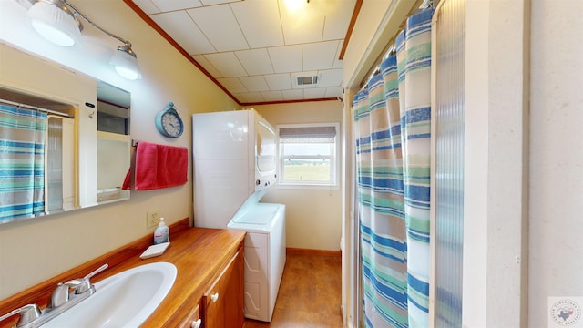 bathroom with stacked washer / drying machine and vanity