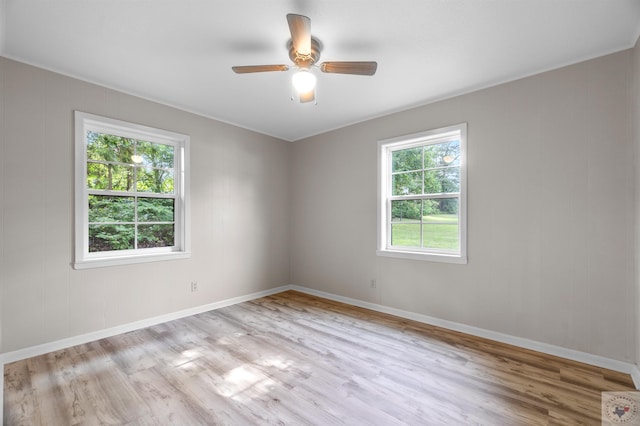 empty room with ceiling fan, a healthy amount of sunlight, and light hardwood / wood-style flooring