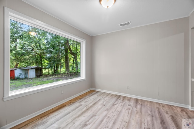 empty room featuring light hardwood / wood-style floors and crown molding