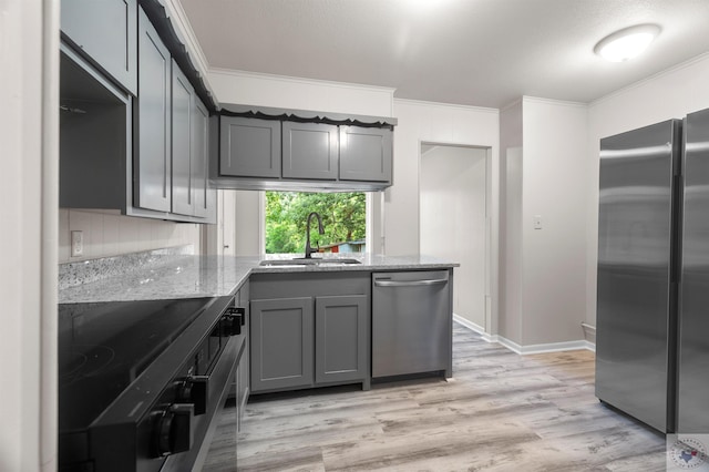 kitchen with crown molding, light stone countertops, gray cabinetry, sink, and stainless steel appliances