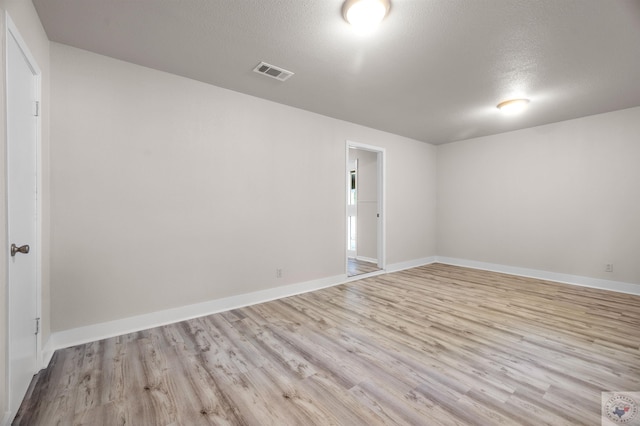 empty room featuring light hardwood / wood-style flooring and a textured ceiling