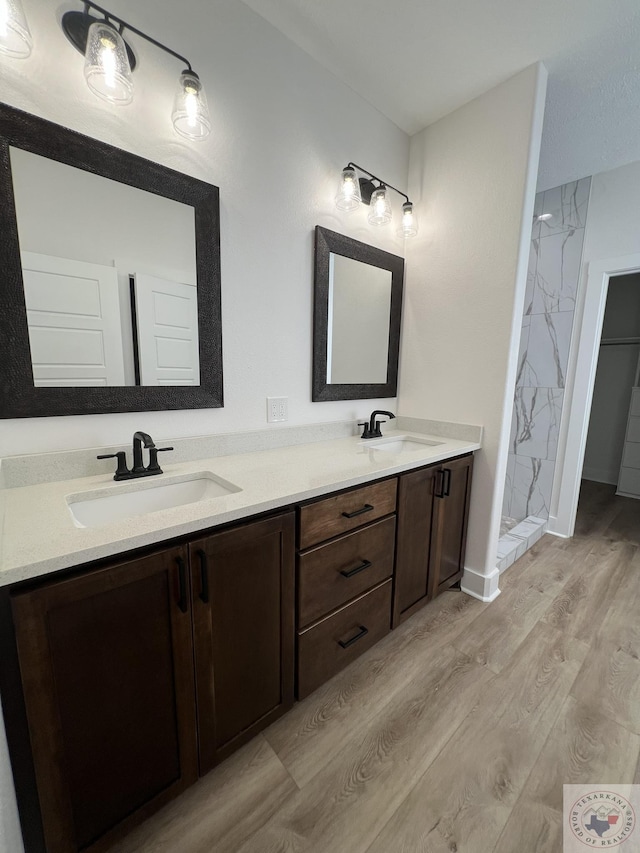 bathroom featuring vanity, hardwood / wood-style floors, and tiled shower