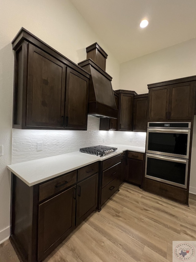 kitchen featuring appliances with stainless steel finishes, light hardwood / wood-style flooring, and dark brown cabinets