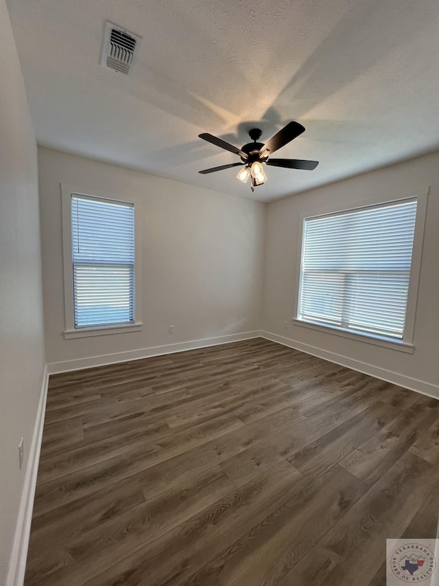 empty room featuring ceiling fan and dark hardwood / wood-style flooring