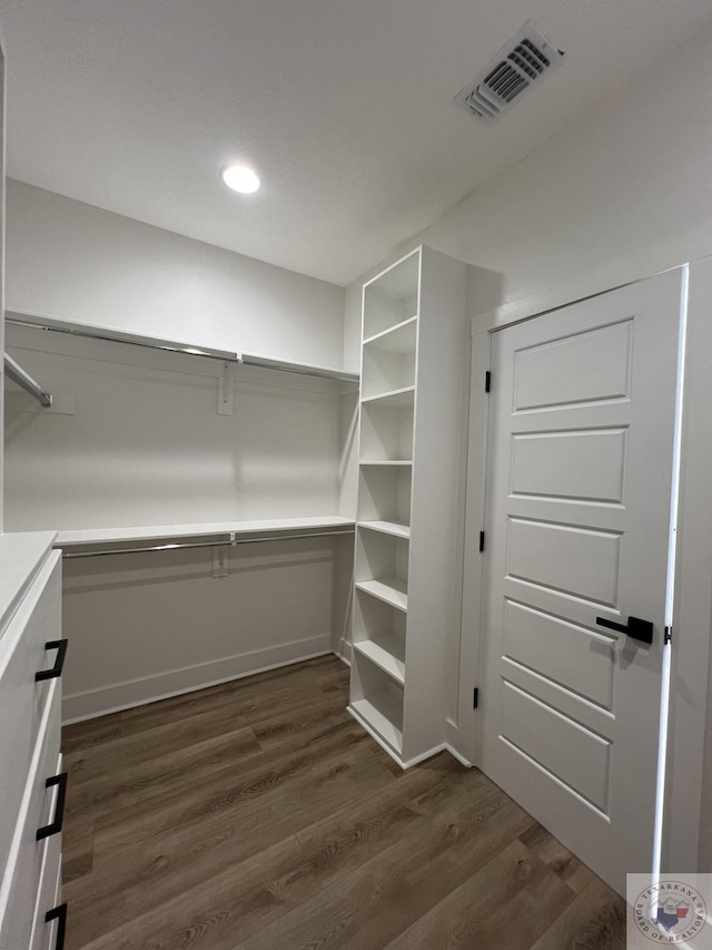 spacious closet with dark hardwood / wood-style flooring