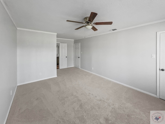 carpeted empty room featuring ceiling fan, crown molding, and a textured ceiling