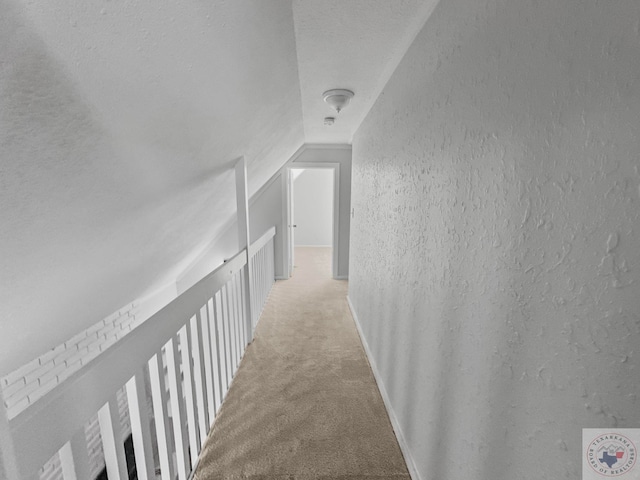 corridor featuring vaulted ceiling, carpet, and a textured ceiling