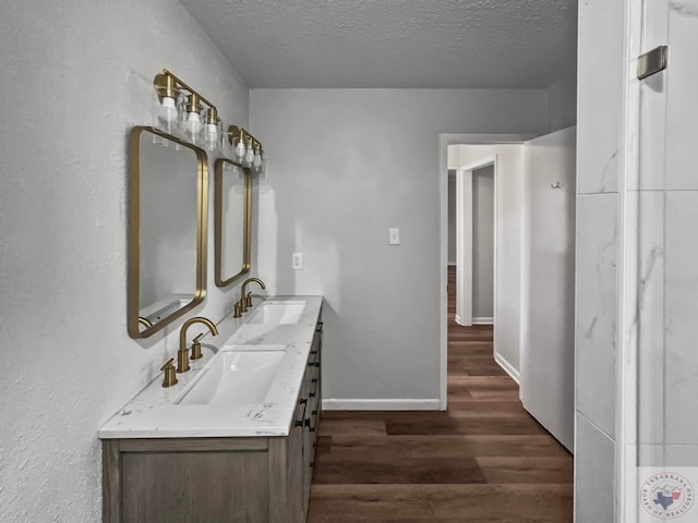 bathroom featuring vanity, hardwood / wood-style flooring, and a textured ceiling