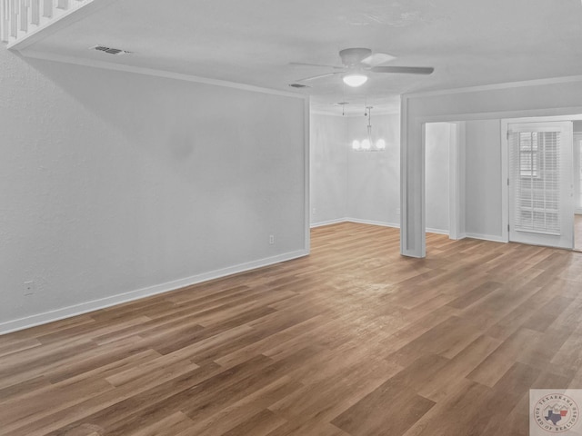 empty room with crown molding, hardwood / wood-style floors, and ceiling fan with notable chandelier